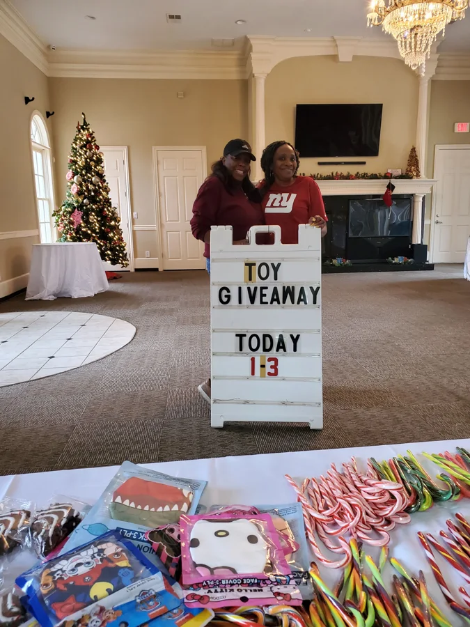 A GSG volunteer holding a toy giveaway sign
