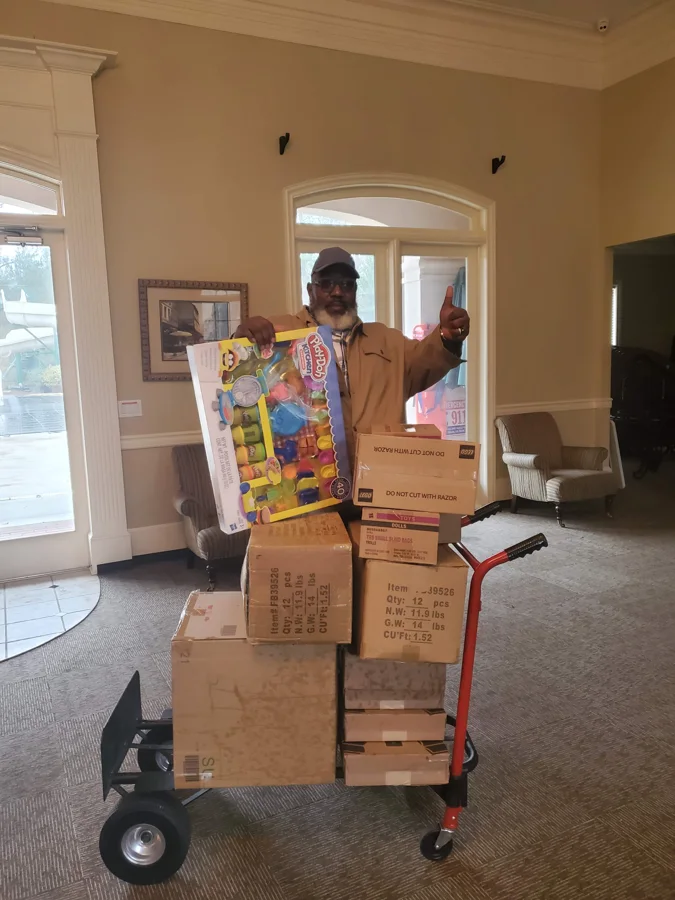 A GSG volunteer with a cart of donated toys